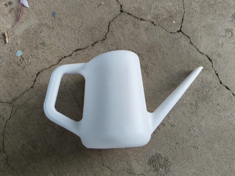 Small narrow-spout watering can used to precisely water succulents and shelf plants in a compact container garden.